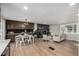 Open-concept living room with a fireplace, modern furniture, and dining area with wood flooring at 7882 S Independence Way, Littleton, CO 80128