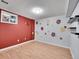 Basement bedroom with red accent wall and rose stencil at 12644 W Virginia Ave, Lakewood, CO 80228