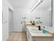 Bright bathroom featuring double sinks, white cabinets and large mirror with Hollywood-style vanity lighting at 1861 Mallard Dr, Superior, CO 80027