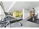 Bright gym with floor-to-ceiling windows with treadmills, stationary bike and weight machines at 1155 N Ash St # 102, Denver, CO 80220