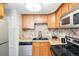 Well-lit kitchen features wood cabinetry, granite countertops, stainless appliances, and decorative backsplash at 1155 N Ash St # 102, Denver, CO 80220