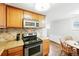 Well-lit kitchen features wood cabinetry, granite countertops, stainless appliances, and decorative backsplash at 1155 N Ash St # 102, Denver, CO 80220