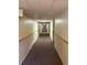 Long hallway with carpet flooring and neutral wall color leading toward a distant window at 14751 E Tennessee Dr # 213, Aurora, CO 80012