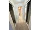 Carpeted hallway with mirrored closets leading to the bathroom showcases ample storage space at 14751 E Tennessee Dr # 213, Aurora, CO 80012