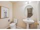 Stylish powder room featuring modern fixtures, a pedestal sink, and a decorative mirror at 12827 W Burgundy Pl, Littleton, CO 80127