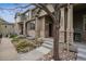 Inviting townhome exterior with stone accents, manicured landscaping, and covered front porch with stately support columns at 12827 W Burgundy Pl, Littleton, CO 80127
