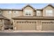 Townhome featuring a two-car garage with stone accents and well-maintained exterior, adding curb appeal to the property at 12827 W Burgundy Pl, Littleton, CO 80127