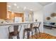 Kitchen featuring a breakfast bar with seating, wood cabinets, and flows into the living room at 12827 W Burgundy Pl, Littleton, CO 80127