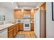 Bright kitchen with wood cabinets, white appliances, ample counter space, and hardwood floors at 12827 W Burgundy Pl, Littleton, CO 80127