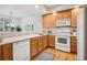 Well-lit kitchen features wood cabinets, white appliances, and a functional layout at 12827 W Burgundy Pl, Littleton, CO 80127