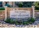 Stone community welcome sign with manicured landscaping, showcasing a well-maintained and inviting neighborhood entrance at 12827 W Burgundy Pl, Littleton, CO 80127