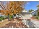 Two-story house with beige siding, attached garage, and autumn leaves at 9441 Wolfe St, Highlands Ranch, CO 80129