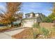 Two-story house with beige siding, attached garage, and autumn leaves at 9441 Wolfe St, Highlands Ranch, CO 80129