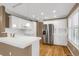 White kitchen with stainless steel appliances and breakfast bar at 9441 Wolfe St, Highlands Ranch, CO 80129