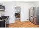 Bright kitchen featuring stainless steel appliances, wood floors, and an open view to the cozy living room at 5680 W 41St Ave, Wheat Ridge, CO 80212