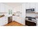 Bright kitchen featuring stainless steel appliances, quartz countertops, and wood flooring at 5680 W 41St Ave, Wheat Ridge, CO 80212