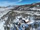Scenic aerial view of a snow-covered property featuring a large home near a lake and surrounded by mountains and forest at 300 Gold Hill Rd, Breckenridge, CO 80424
