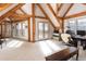 Upstairs bonus room with exposed wooden beams, carpet, and access to a balcony with beautiful mountain views at 300 Gold Hill Rd, Breckenridge, CO 80424
