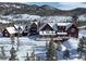 Stunning mountain home featuring a vast deck, beautiful wood siding, and snow-covered roof amid a picturesque winter landscape at 300 Gold Hill Rd, Breckenridge, CO 80424