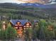 Stunning exterior view of a mountain home surrounded by lush trees and a breathtaking mountain backdrop at 300 Gold Hill Rd, Breckenridge, CO 80424
