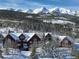 Stunning exterior of a mountain home with snow-covered roof and backdrop of snow-capped peaks at 300 Gold Hill Rd, Breckenridge, CO 80424