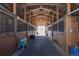 Barn aisle with multiple stalls, wooden construction, and open access to the outdoors at 300 Gold Hill Rd, Breckenridge, CO 80424