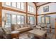 Bright living room featuring exposed wood beams, large windows, and stylish, antique furniture with lovely details at 300 Gold Hill Rd, Breckenridge, CO 80424