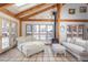 Bright sunroom with tile flooring, exposed wood beams, comfortable seating, fireplace and natural light at 300 Gold Hill Rd, Breckenridge, CO 80424