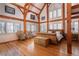 Bright main bedroom with exposed wooden beams, hardwood floors, and large windows with serene outdoor views at 300 Gold Hill Rd, Breckenridge, CO 80424