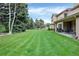 Lush backyard with mature trees and patio area, perfect for relaxation and entertainment at 9669 E Prentice Cir, Greenwood Village, CO 80111