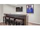 Finished basement with a bar area, complete with seating and a mounted television at 9669 E Prentice Cir, Greenwood Village, CO 80111