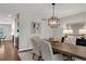 Dining room featuring a modern chandelier, six upholstered chairs, and a decorative mirror at 9669 E Prentice Cir, Greenwood Village, CO 80111