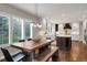 Dining room with a wooden table and bench seating, large windows, and an open view to the kitchen at 9669 E Prentice Cir, Greenwood Village, CO 80111