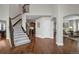 Elegant foyer with hardwood floors, staircase with iron railing, and access to multiple living areas at 9669 E Prentice Cir, Greenwood Village, CO 80111