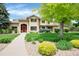Inviting two-story home features a red door, lush landscaping, and well-manicured lawn at 9669 E Prentice Cir, Greenwood Village, CO 80111