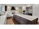 Gourmet kitchen featuring a large island, stainless steel appliances, white cabinets, and hardwood floors at 9669 E Prentice Cir, Greenwood Village, CO 80111