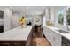 Bright kitchen boasts white cabinets, a large island with seating, and stainless steel appliances at 9669 E Prentice Cir, Greenwood Village, CO 80111