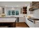 Bright kitchen features white cabinets, a large window, stainless steel appliances, and hardwood floors at 9669 E Prentice Cir, Greenwood Village, CO 80111