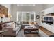 Bright and cozy living room with a comfortable sectional, custom built-ins, and large windows at 9669 E Prentice Cir, Greenwood Village, CO 80111
