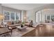 Living room featuring large windows with shutters, neutral decor, hardwood floors, and an open entrance at 9669 E Prentice Cir, Greenwood Village, CO 80111