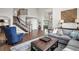 Spacious open-concept living room with hardwood floors, soaring ceilings, and an elegant staircase at 9669 E Prentice Cir, Greenwood Village, CO 80111