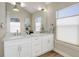 Bright bathroom with a double sink vanity, large mirror, and window at 19810 County Road 1, Berthoud, CO 80513