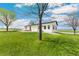 Well-maintained lawn with mature trees framing a charming home with an inviting patio area at 19810 County Road 1, Berthoud, CO 80513
