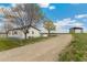 Quaint home with fenced yard, mature trees, and shed or outbuilding in the background at 19810 County Road 1, Berthoud, CO 80513