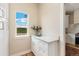Bright hallway featuring white cabinets, countertops, and a window with a serene view at 19810 County Road 1, Berthoud, CO 80513