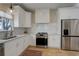 Modern kitchen with stainless steel appliances, white cabinetry, and a tile backsplash at 19810 County Road 1, Berthoud, CO 80513