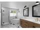 Modern bathroom featuring double sinks, bathtub, a sleek glass shower, and herringbone tile floors at 24355 E Briarwood Ave, Aurora, CO 80016