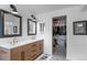 Bright bathroom featuring double sinks, modern fixtures, and a doorway to a walk-in closet at 24355 E Briarwood Ave, Aurora, CO 80016