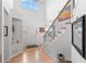 Bright foyer features wood floors, staircase with iron railing, soaring ceilings, and decorative lighting at 24355 E Briarwood Ave, Aurora, CO 80016