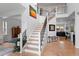 Bright foyer features wood floors, staircase with iron railing, soaring ceilings, and decorative lighting at 24355 E Briarwood Ave, Aurora, CO 80016